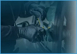 Close-up of a person wearing black gloves performing tire maintenance on a vehicle.