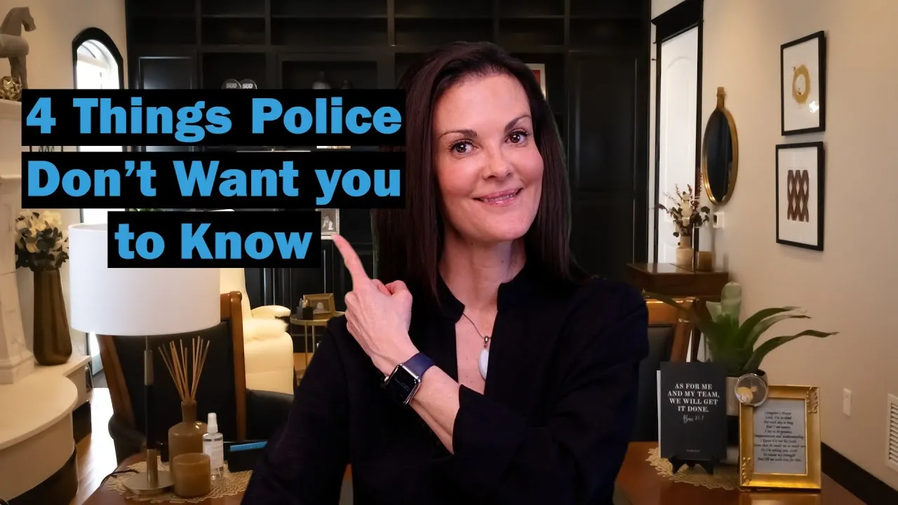 Woman with dark hair smiling and pointing to blue text that reads "4 Things Police Don’t Want you to Know" in a modern living room.