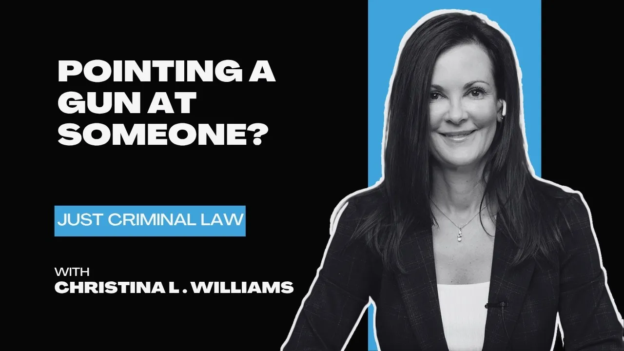Black and blue graphic with text "Pointing a gun at someone?" and photo of woman in blazer smiling.