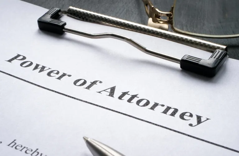 Close-up of a Power of Attorney document clipped on a clipboard with a pen nearby.