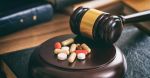 Law gavel and colorful pills on a wooden desk